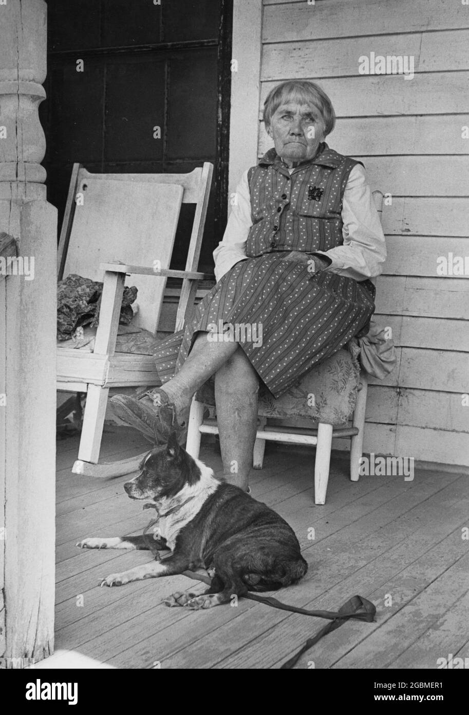 Hearn, Texas USA, 1978: Elderly woman sits on her front porch with her dog in small town in south-central Texas. ©Bob Daemmrich Stock Photo