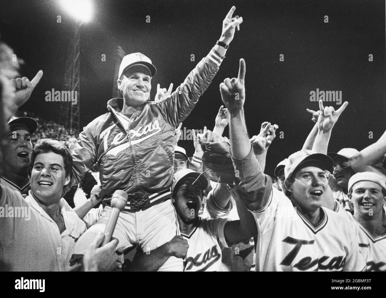 Omaha, Nebraska, USA, 1984: University of Texas baseball coach Cliff Gustafson is carried off the field by his players after UT won the College World Series national championship. ©Bob Daemmrich Stock Photo