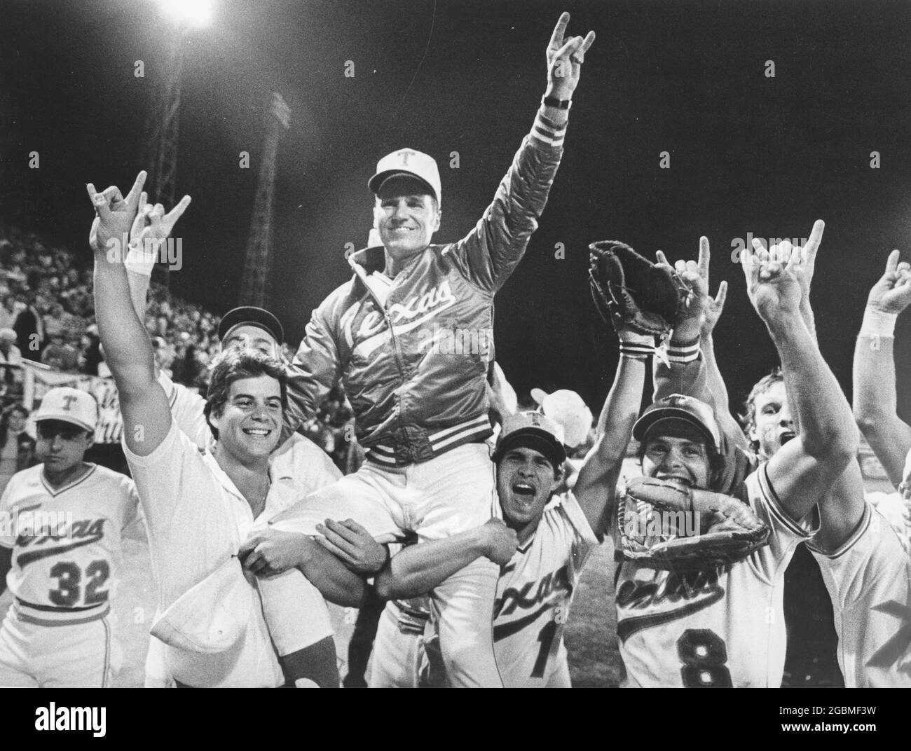 Omaha, Nebraska, USA, 1984: University of Texas baseball coach Cliff Gustafson is carried off the field by his players after UT won the College World Series national championship. ©Bob Daemmrich Stock Photo