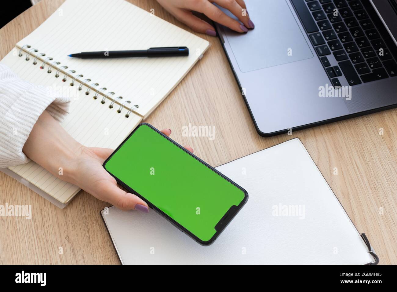 Female hand holding smartphone with chroma key screen. Stock Photo