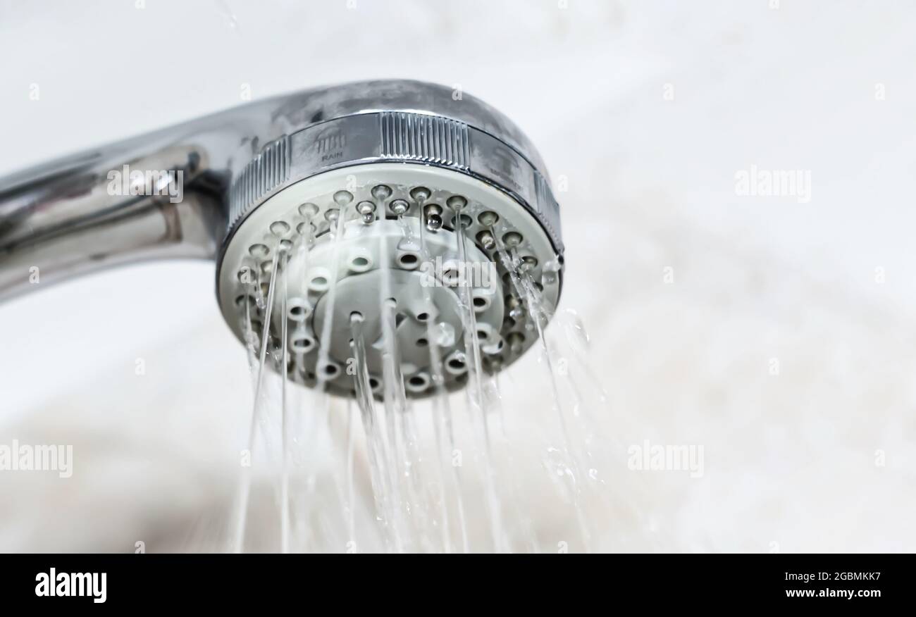 Interior of a shower with water flowing from the shower head. Droplets and moisture. Hygiene and