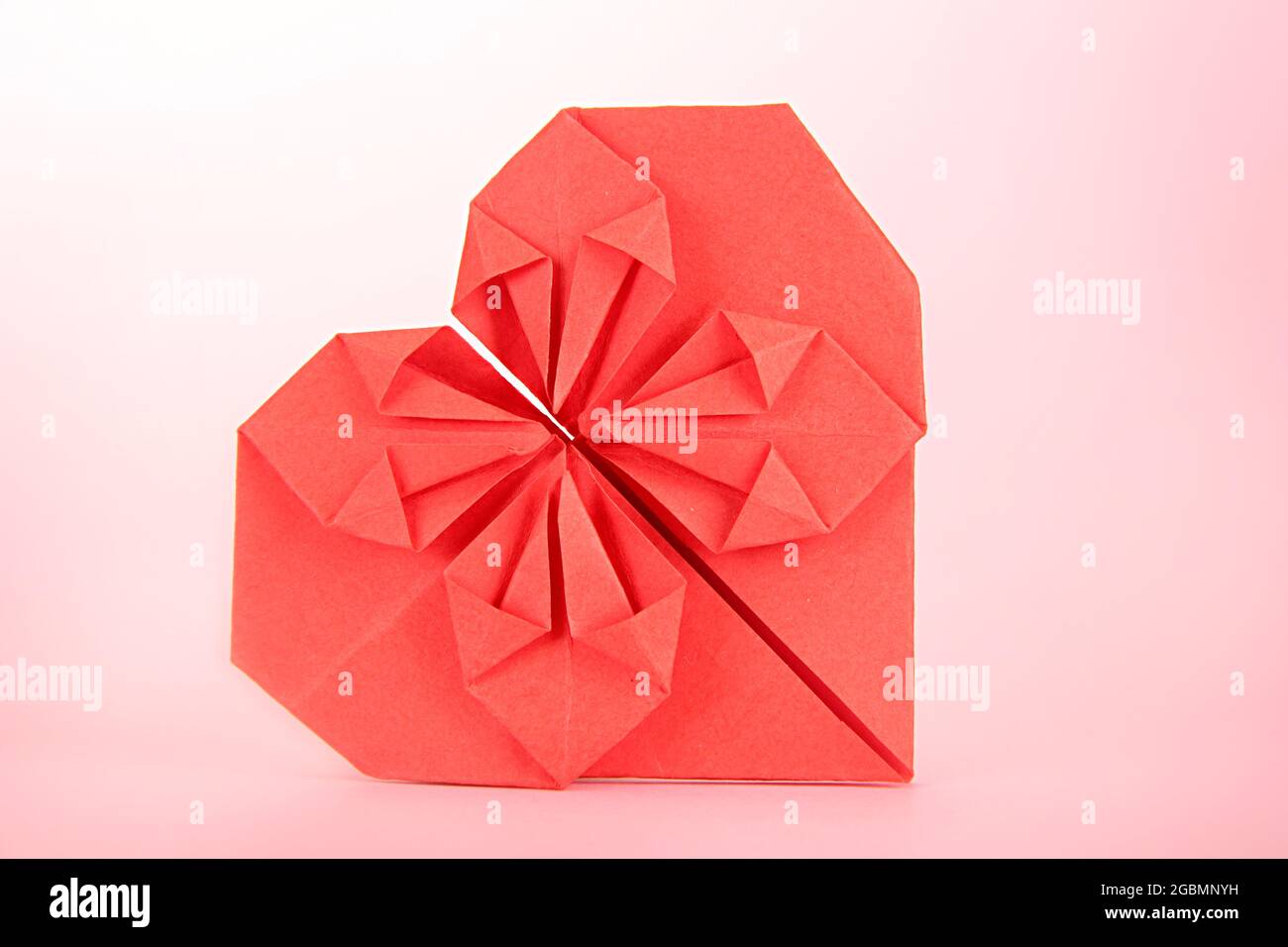 Origami paper heart on pink background Stock Photo - Alamy