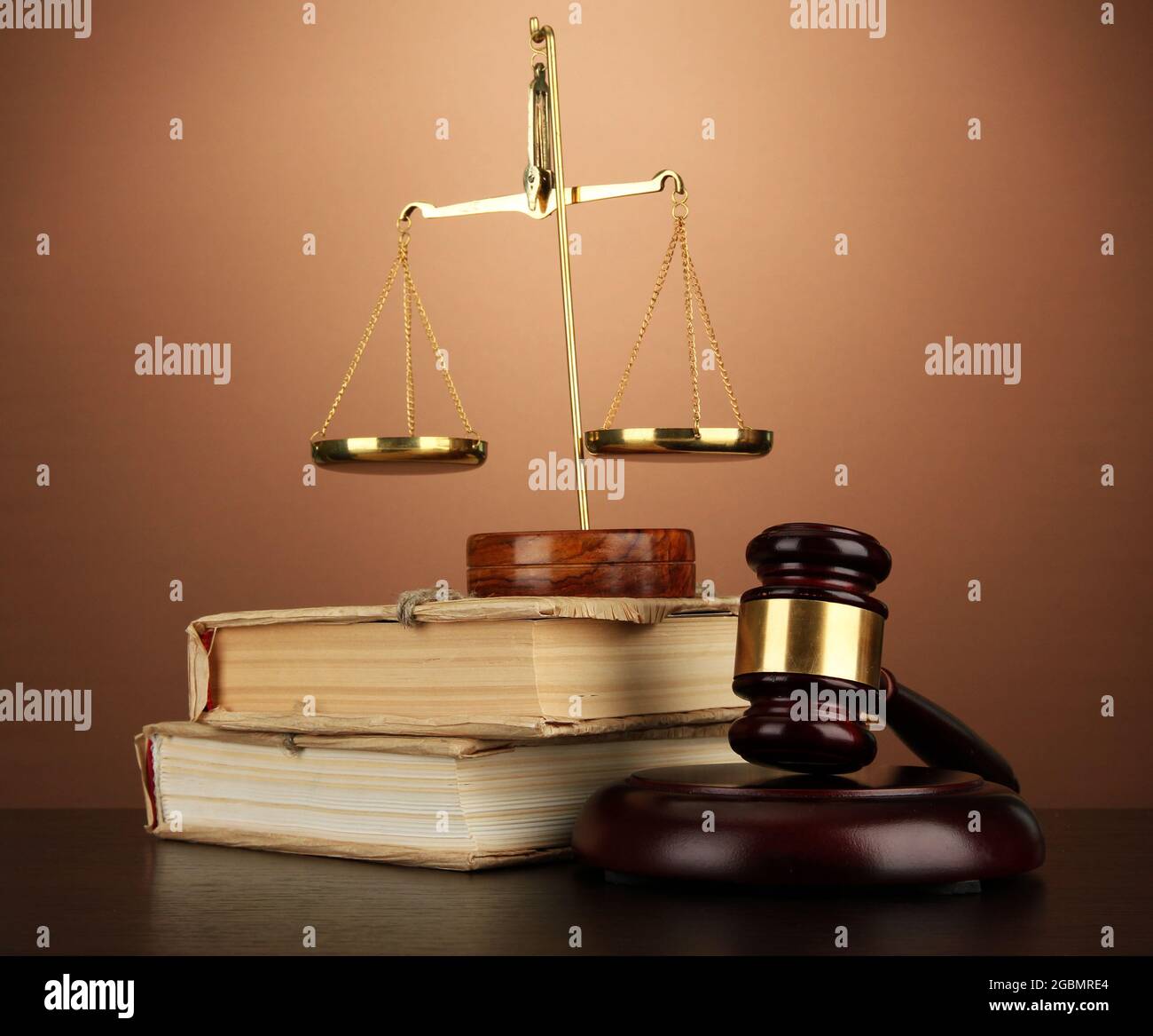 Golden scales of justice, gavel and books on brown background Stock ...