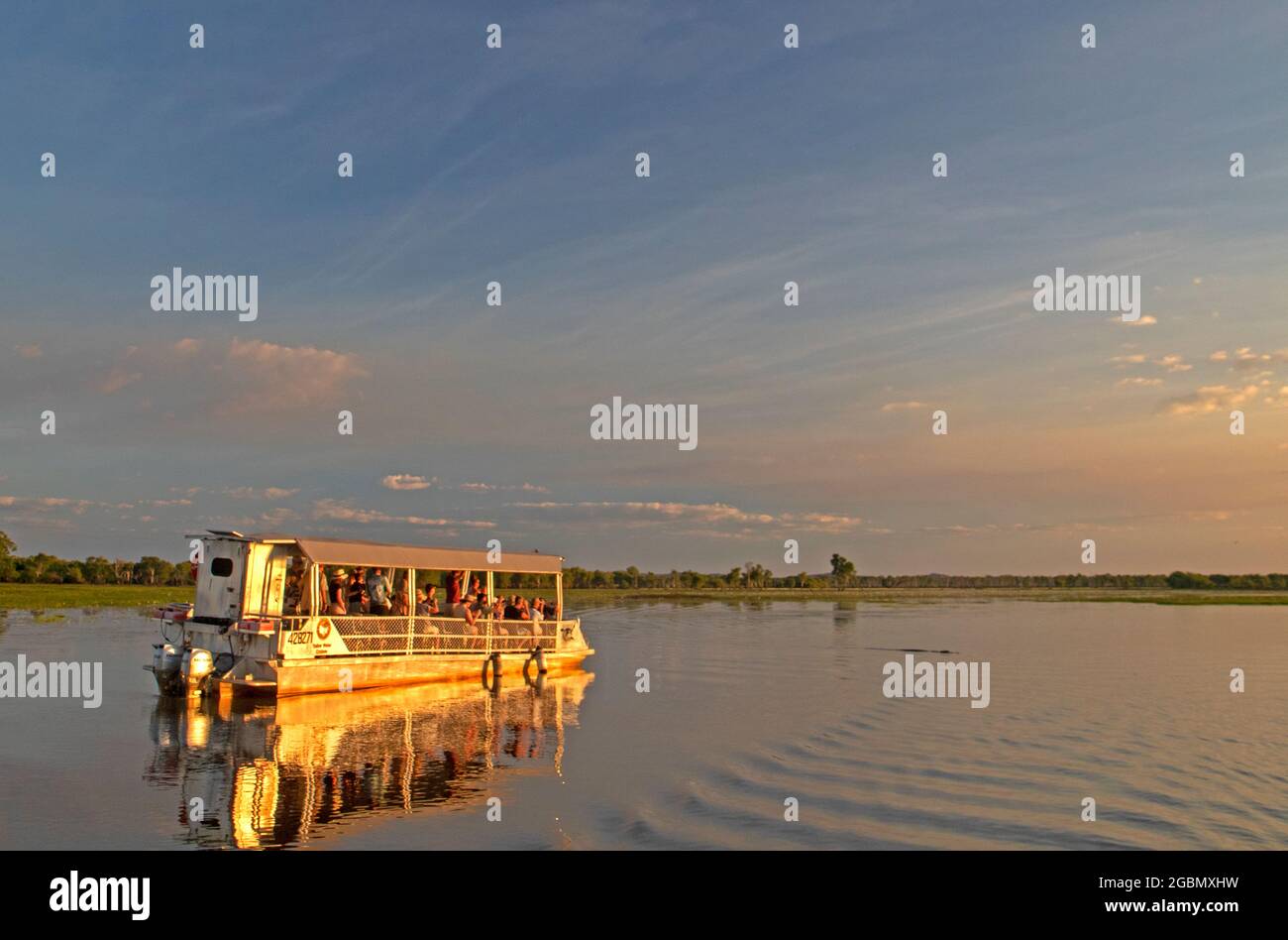 Tourist boat and crocodile at Yellow Water Stock Photo