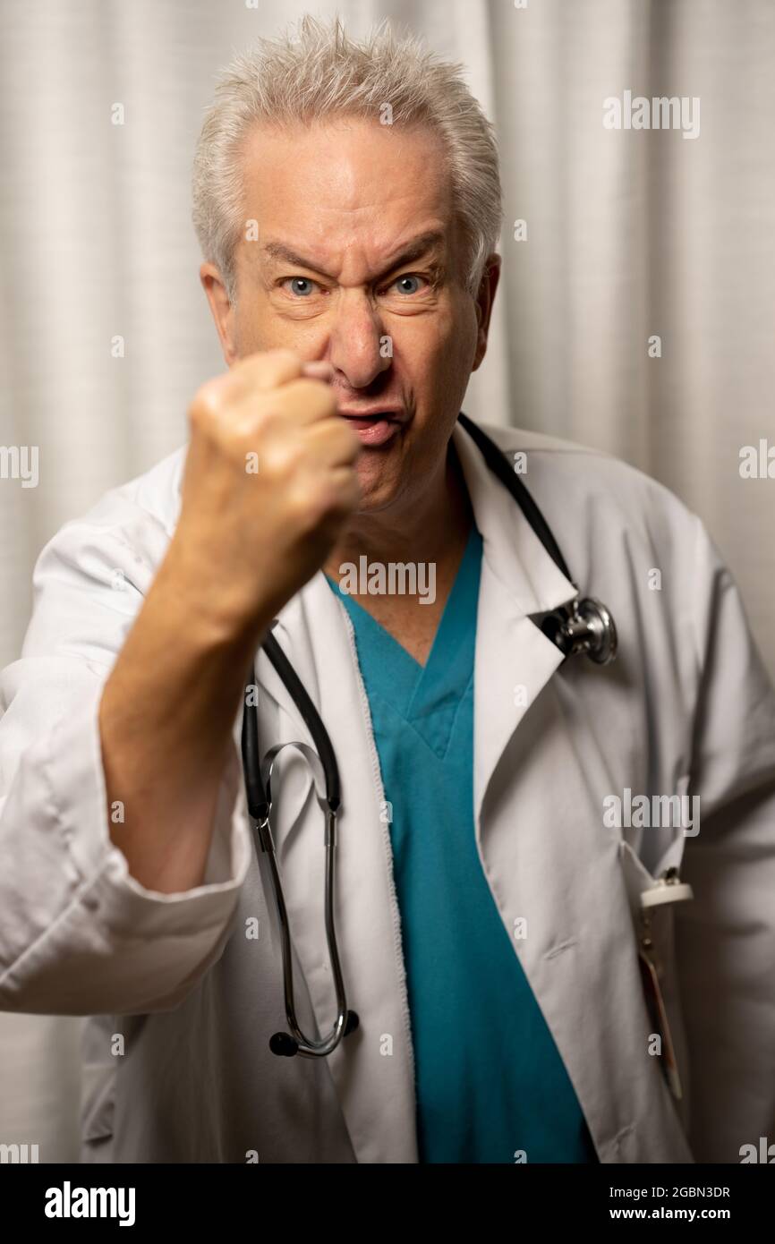 Photo of an angry doctor holding his fist in the air Stock Photo