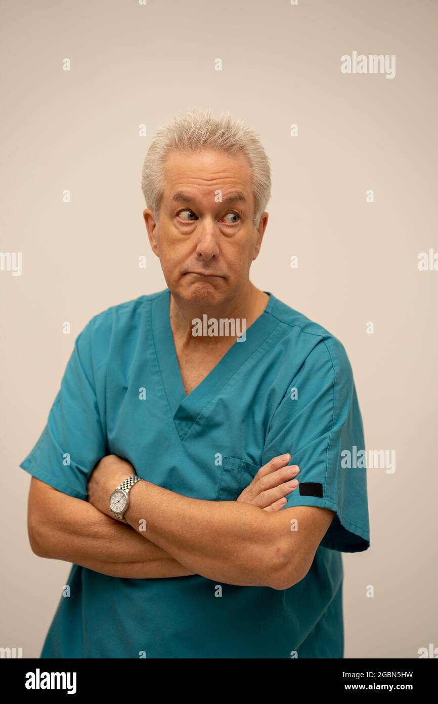 Deadpan expression doctor with arms crossed Stock Photo