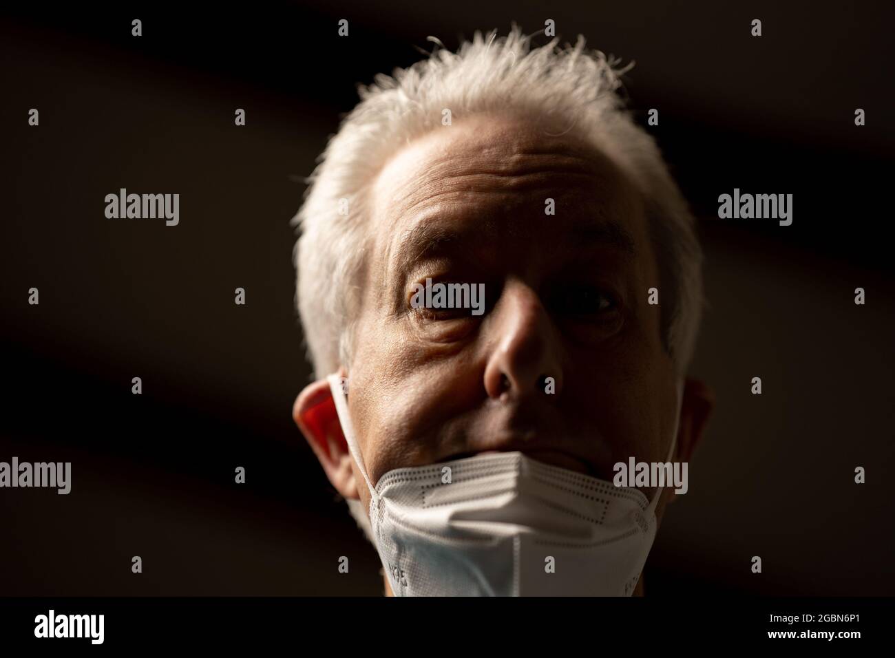 Photo of an old man incorrectly wearing his face mask not covering his nose and mouth Stock Photo