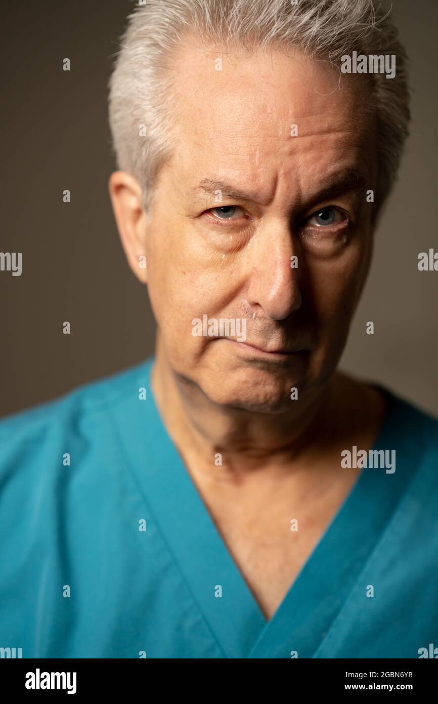 Photo of an old medical doctor crying with tears on face Stock Photo