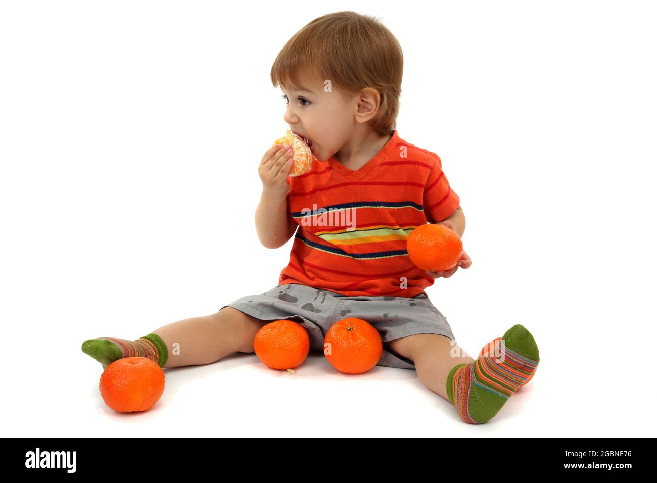 cute little boy eating tangerines, isolated on white Stock Photo Alamy