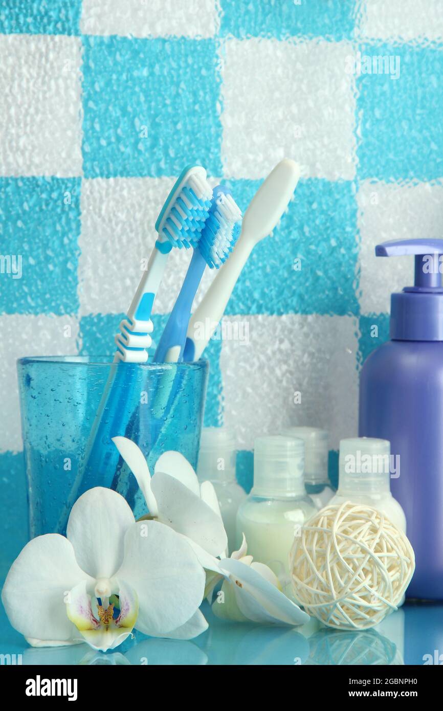 Bath accessories on shelf in bathroom on blue tile wall background ...