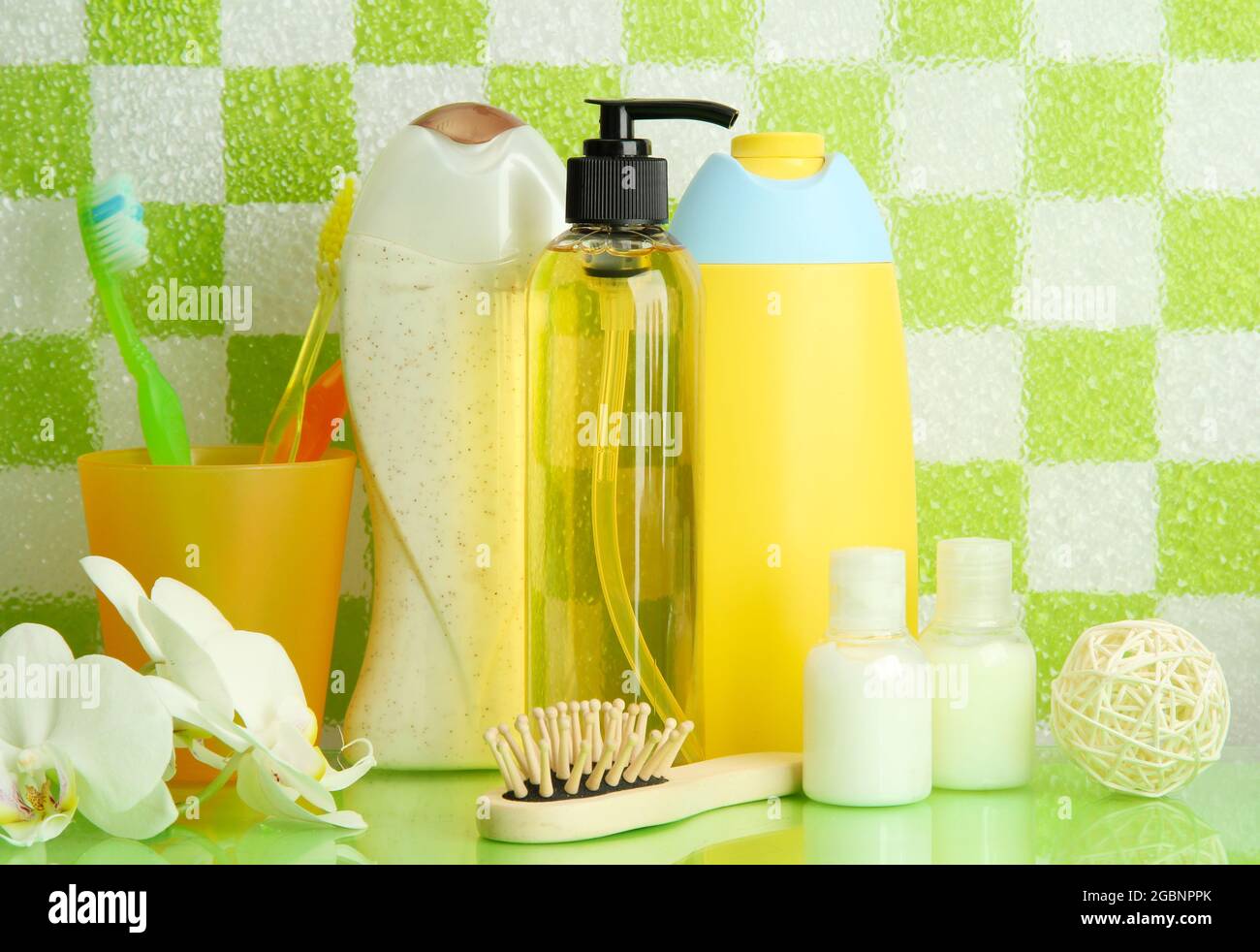 Bath accessories on shelf in bathroom on green tile wall background ...