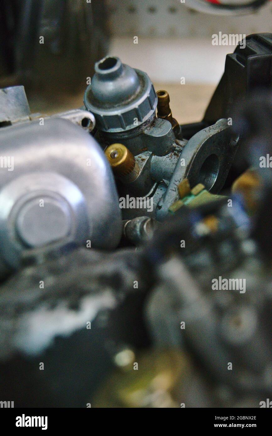 An old carburetor is in a box with many other carburetors and