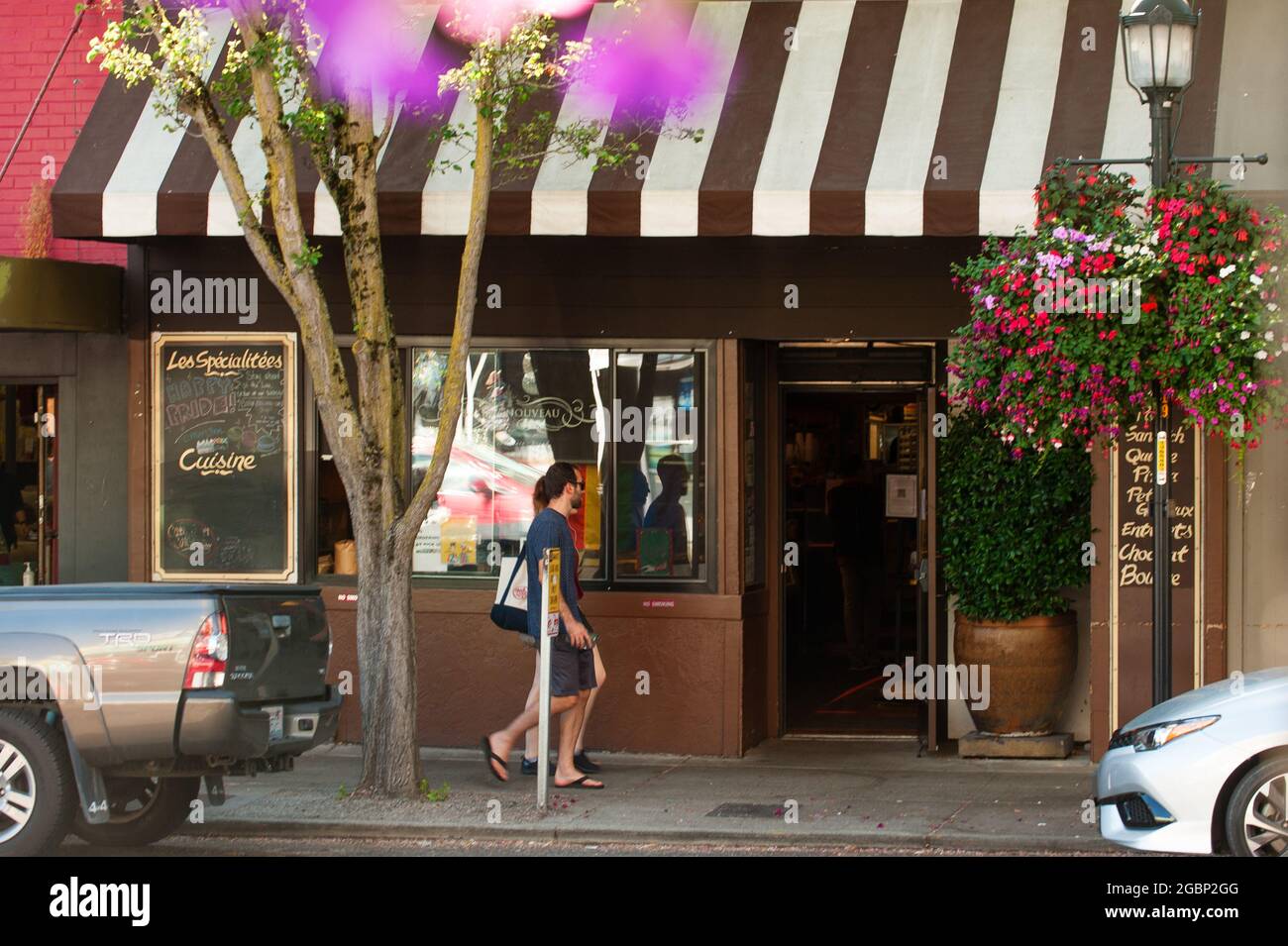 A couple walk past the West Seattle location of Bakery Nouveau in Seattle, WA. Stock Photo