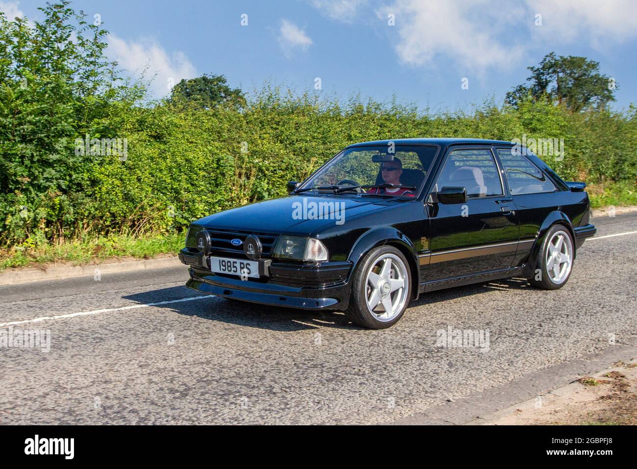 1985 80s black Ford GL RS Turbo 1597cc petrol 2dr sports car en-route to Capesthorne Hall classic July car show, Cheshire, UK Stock Photo