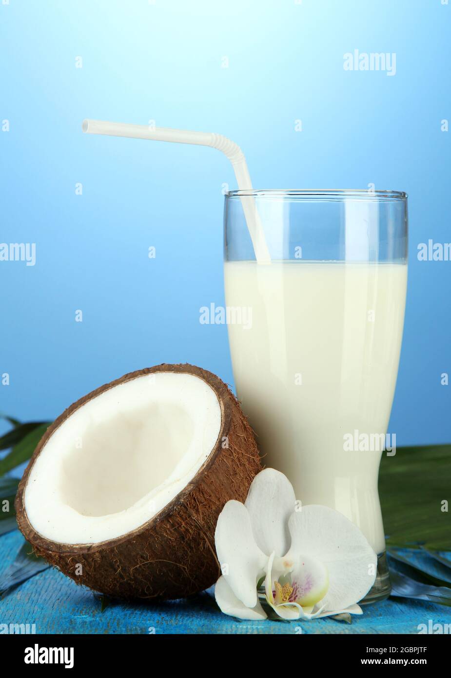 Coconut with glass of milk, on blue background Stock Photo - Alamy
