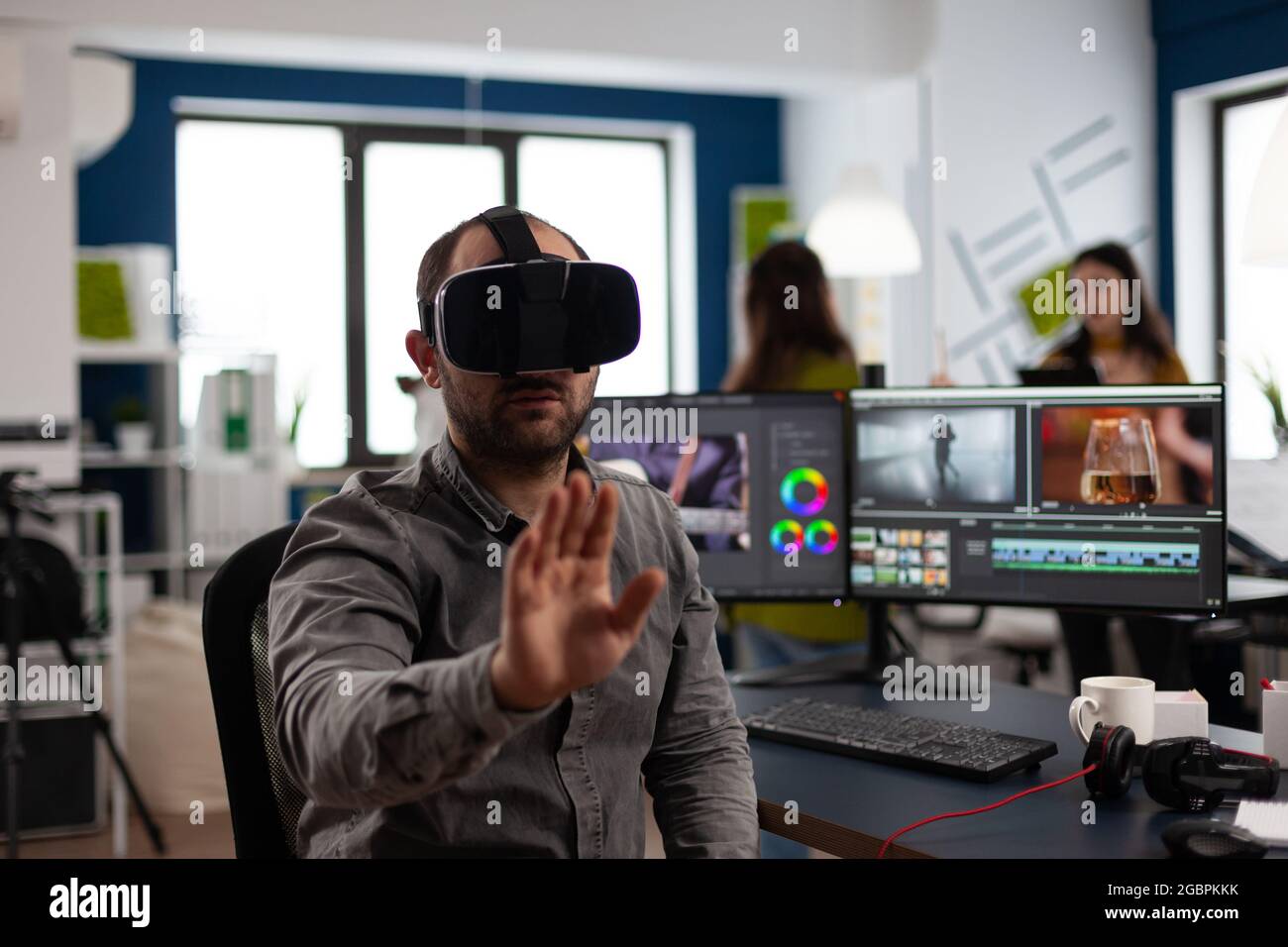 Video editor experiencing virtual reality headset, gesturing, editing film  montage using post production software working in creative company office.  Videographer using VR headset in multimedia agency Stock Photo - Alamy