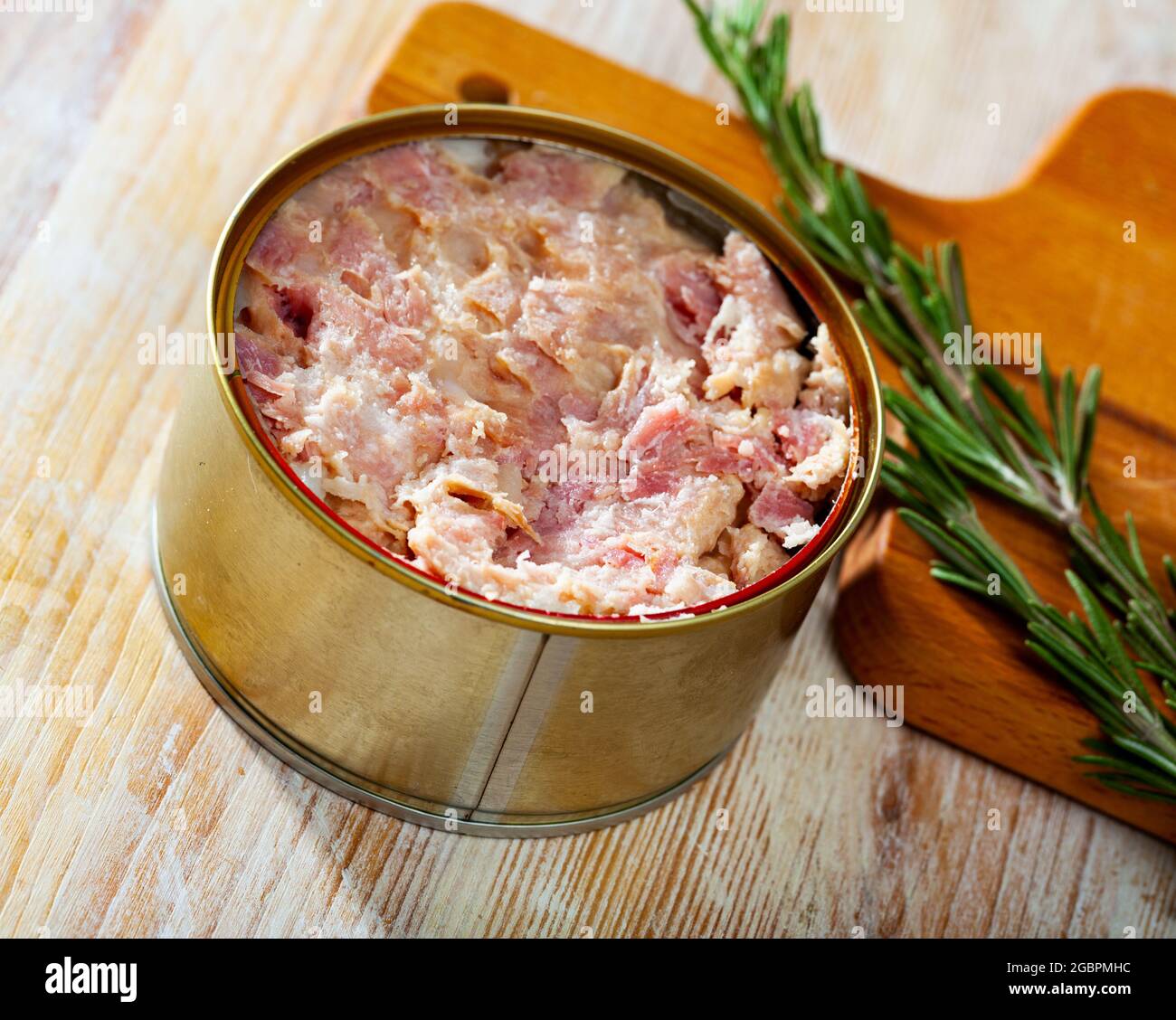 Preserved stewed meat on wooden table Stock Photo