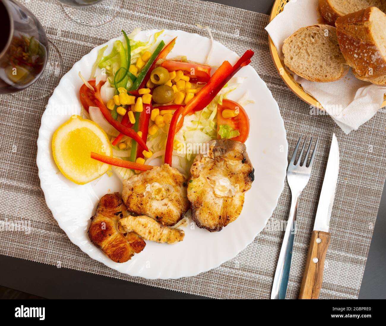Oven baked hake with vegetable garnish Stock Photo