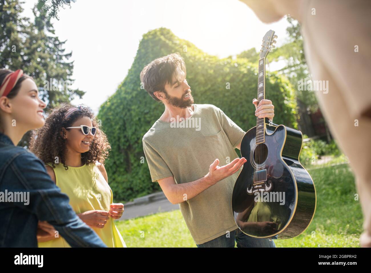 Guy showing guitar and looking friends Stock Photo