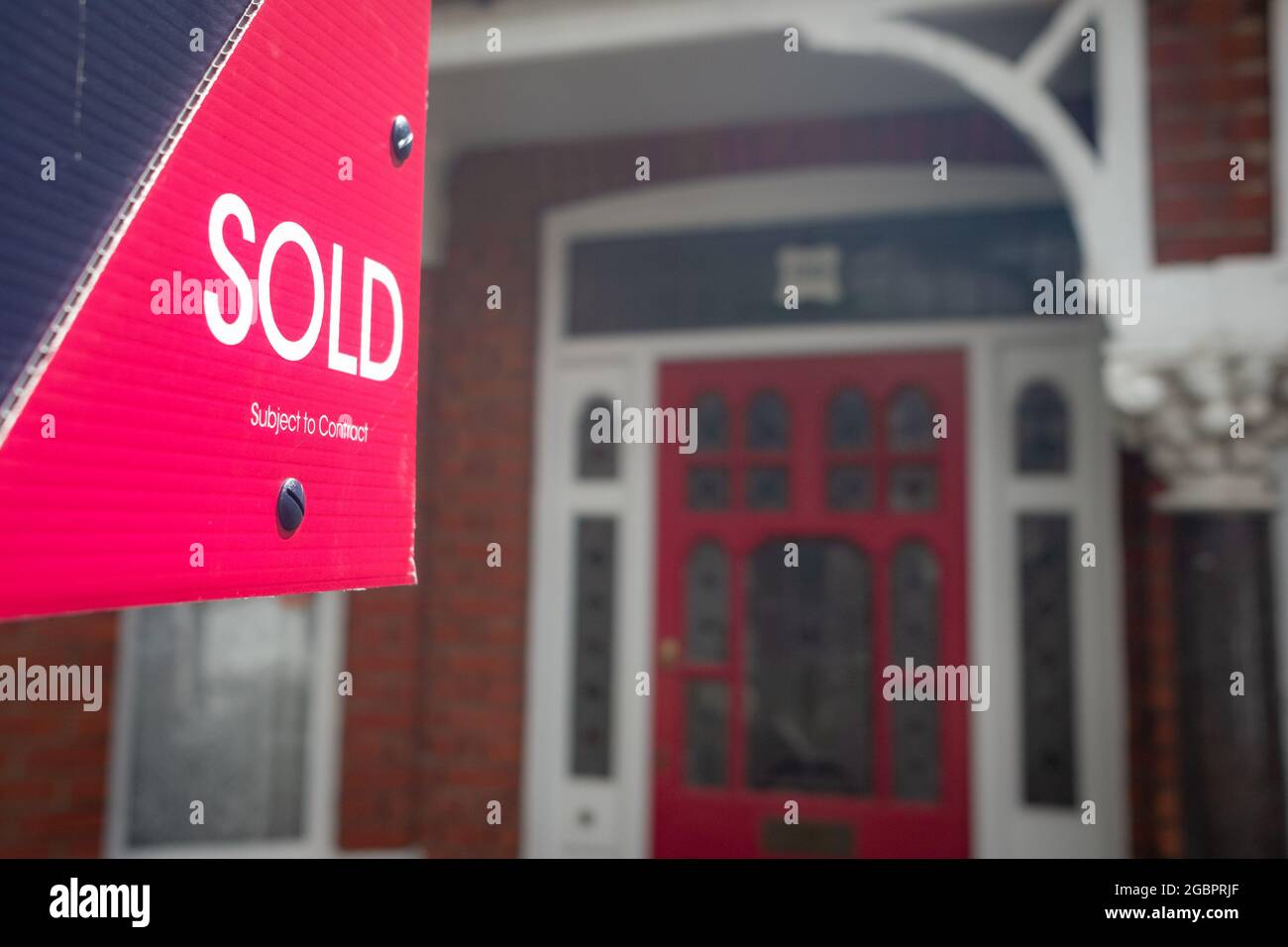 Estate agent 'SOLD' sign on residential street Stock Photo