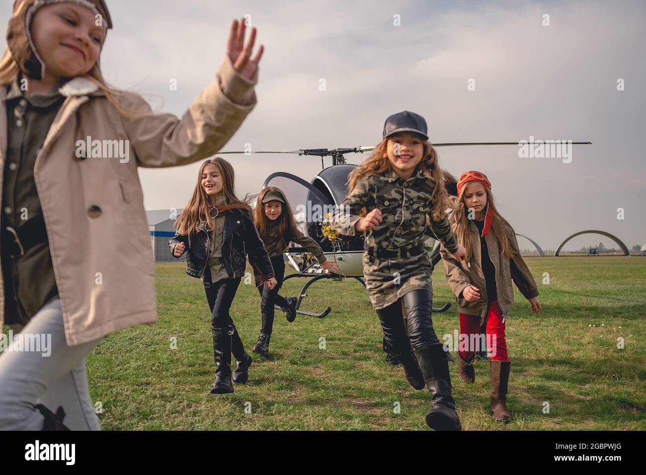 Happy preteen girls running on flying field of aeroclub Stock Photo