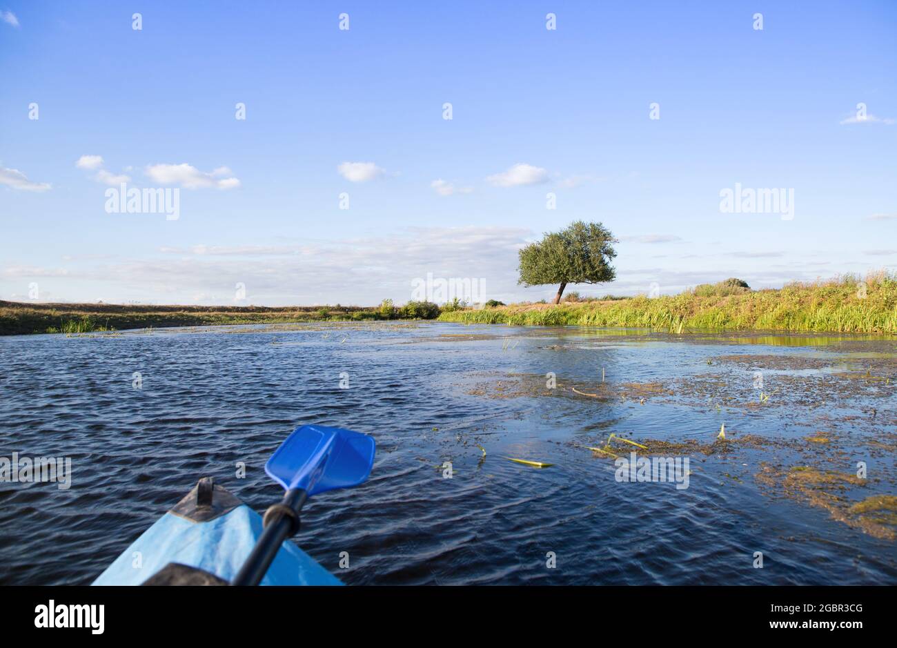 blue paddle lying on a kayak. Outdoor activities, water tourism, sports hobbies, adventures, interesting pastime. Kayaking on the picturesque river. Stock Photo