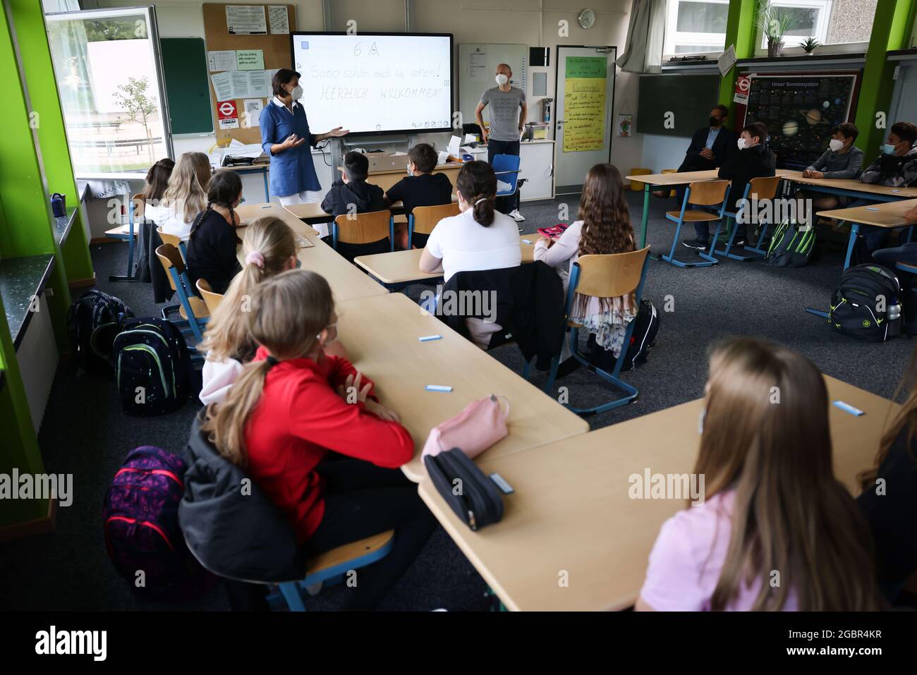 05 August 2021, Hamburg: Elisabeth Bayersdörfer (l) class teacher of class 6a at the Goethe-Gymnasium in Hamburg-Lurup, speaks to the pupils on the first day of school after the holidays. After around six weeks of summer holidays, Hamburg's pupils started the new school year on Thursday, 05.08.2021 - for the second time under Corona conditions. Among other things, the children and young people are still required to wear tests and masks, and a comprehensive hygiene and ventilation concept is in place. Photo: Christian Charisius/dpa Stock Photo