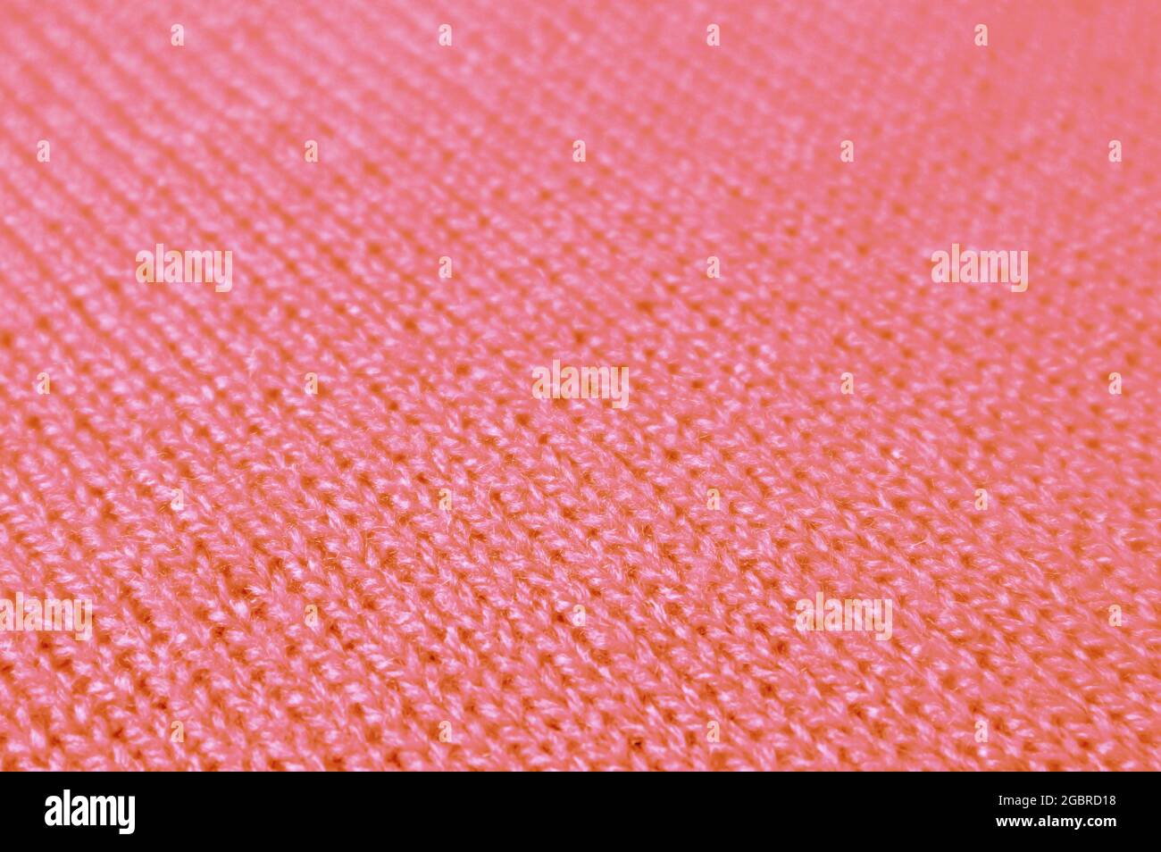 Coral Pink Knitted Wool Fabric in Diagonal Patterns for Abstract Background Stock Photo
