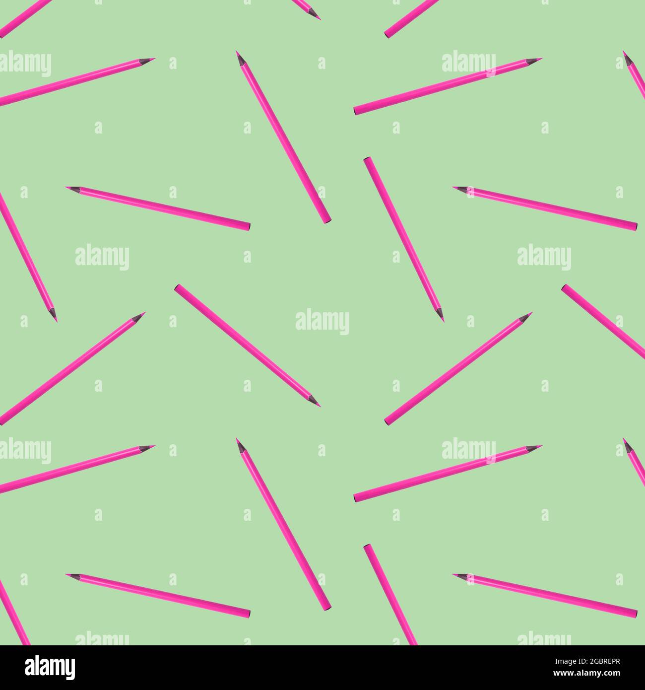 Seamless pattern with pink pencils on green background. Stock Photo
