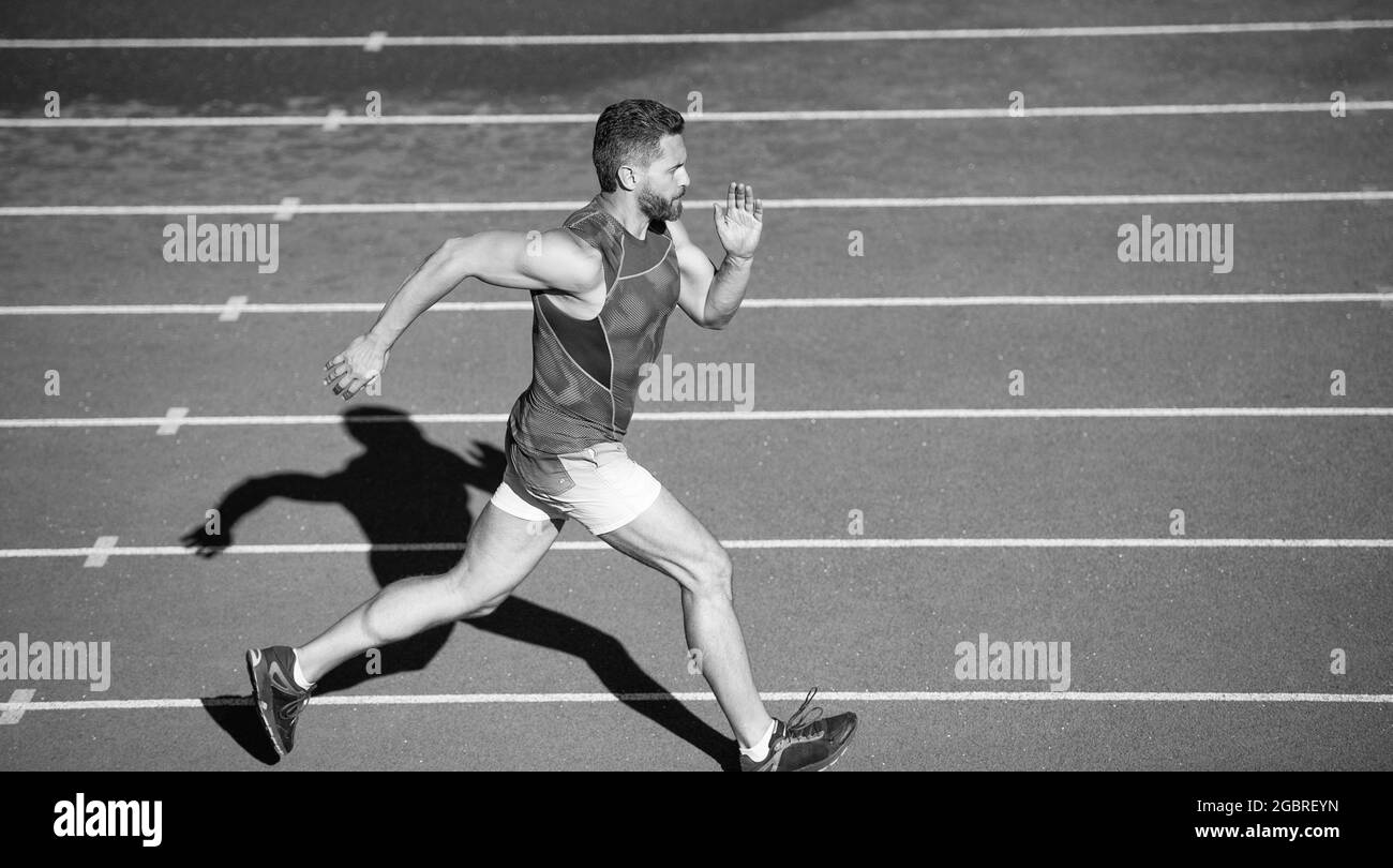 sportsman male in sportswear run fast sprinting on running track, distance Stock Photo