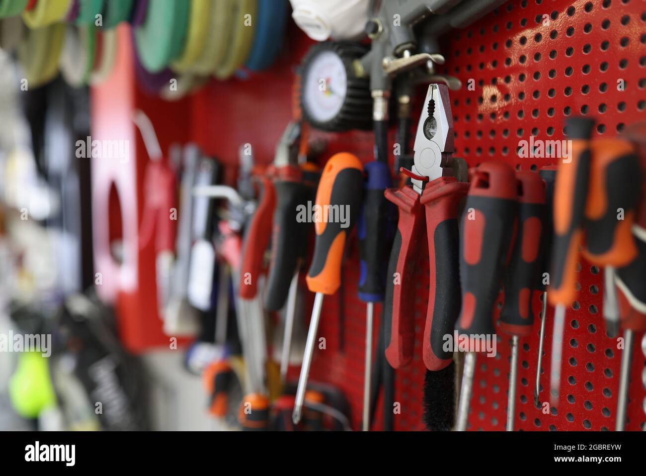 Many working tools hanging on wall in workshop closeup Stock Photo