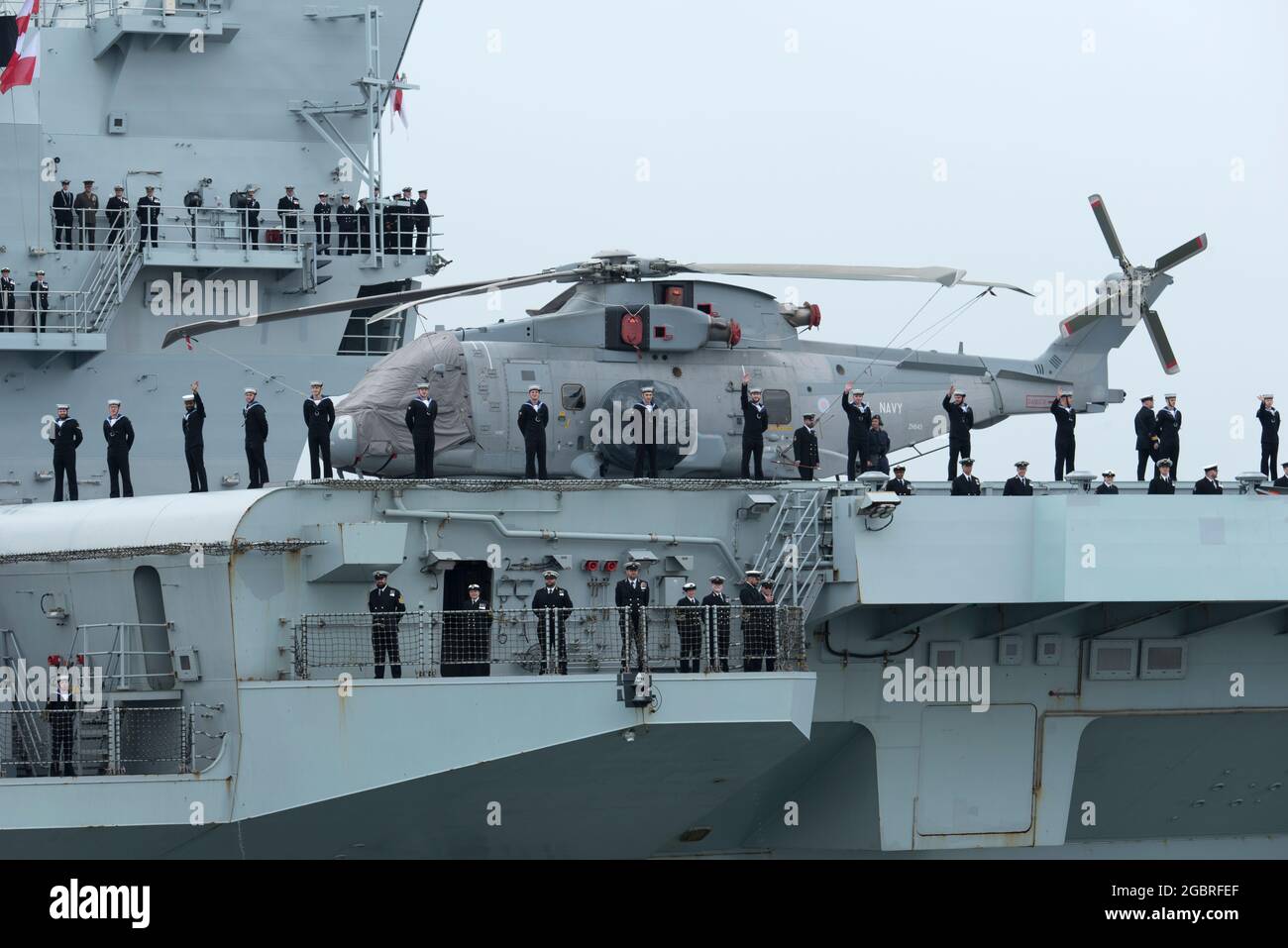 HMS Queen Elizabeth departs Portsmouth carrying Merlin helicopters on deck Stock Photo