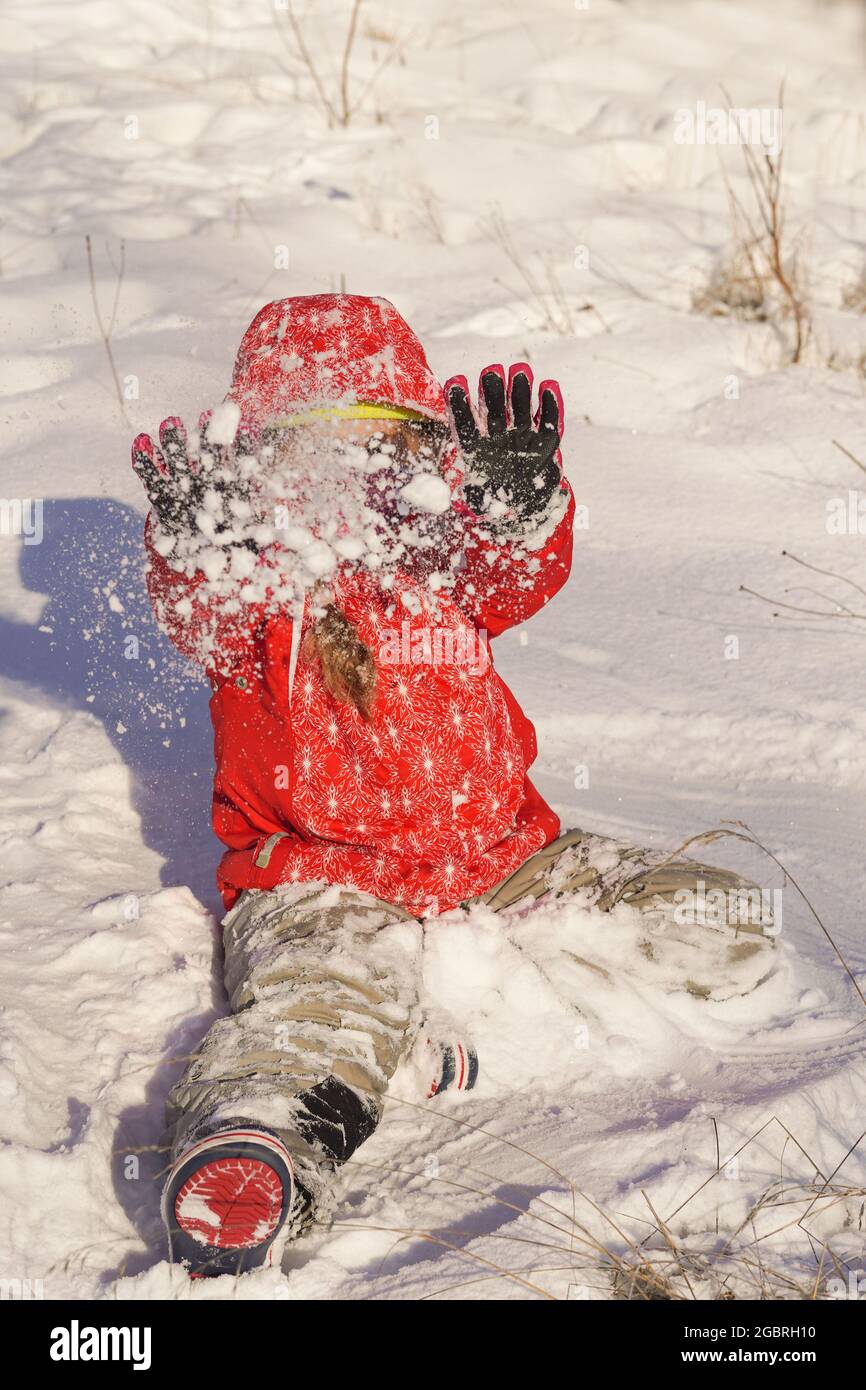 Kid play in the winter park, throw snow and having fun. Children ...