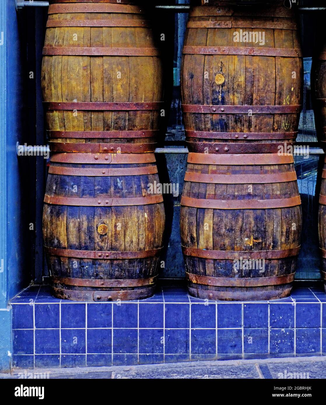 Four wooden pub beer barrels on blue tiled shelf Stock Photo Alamy