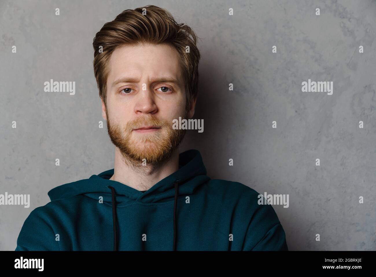 White ginger man with beard posing and looking at camera isolated over grey background Stock Photo