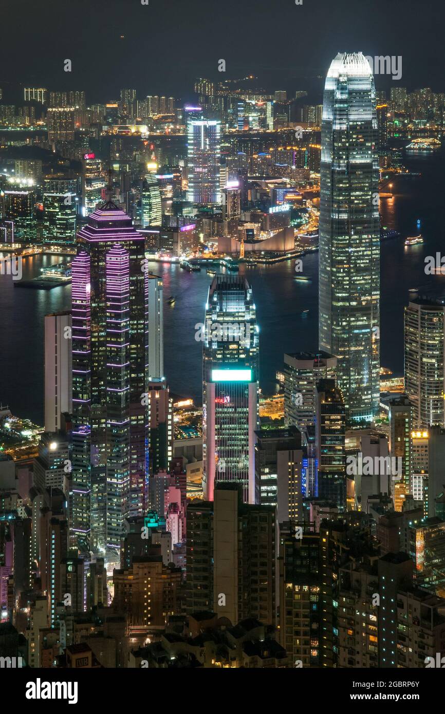 The skyscrapers and high density highrise urban landscape of Mid-levels and Central on Hong Kong Island, and Kowloon across Victoria Harbour, at night Stock Photo