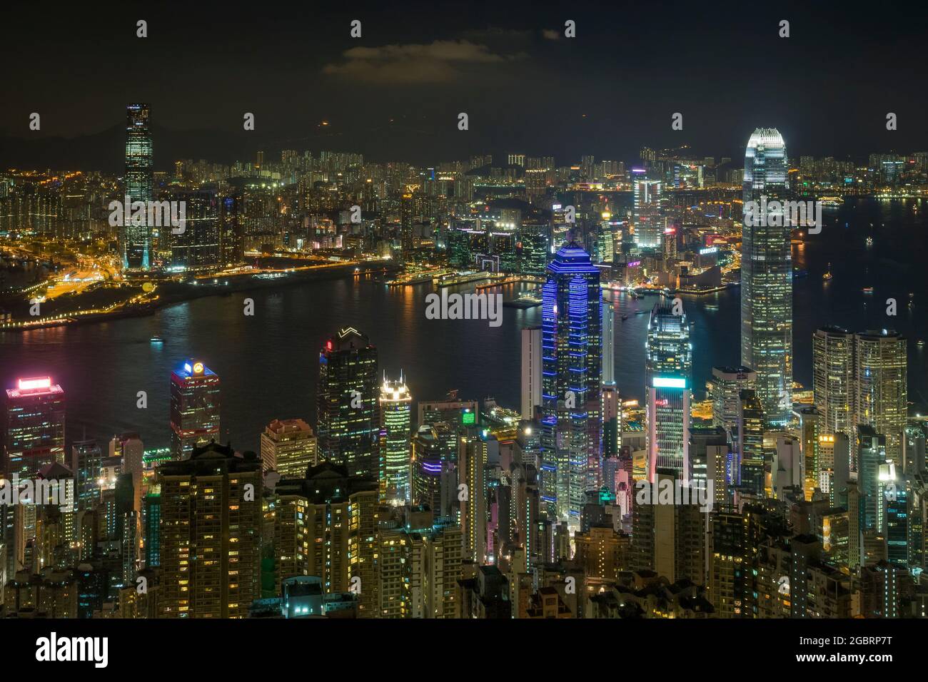 The skyscrapers and high density highrise urban landscape of Mid-levels and Central on Hong Kong Island, and Kowloon across Victoria Harbour, at night Stock Photo