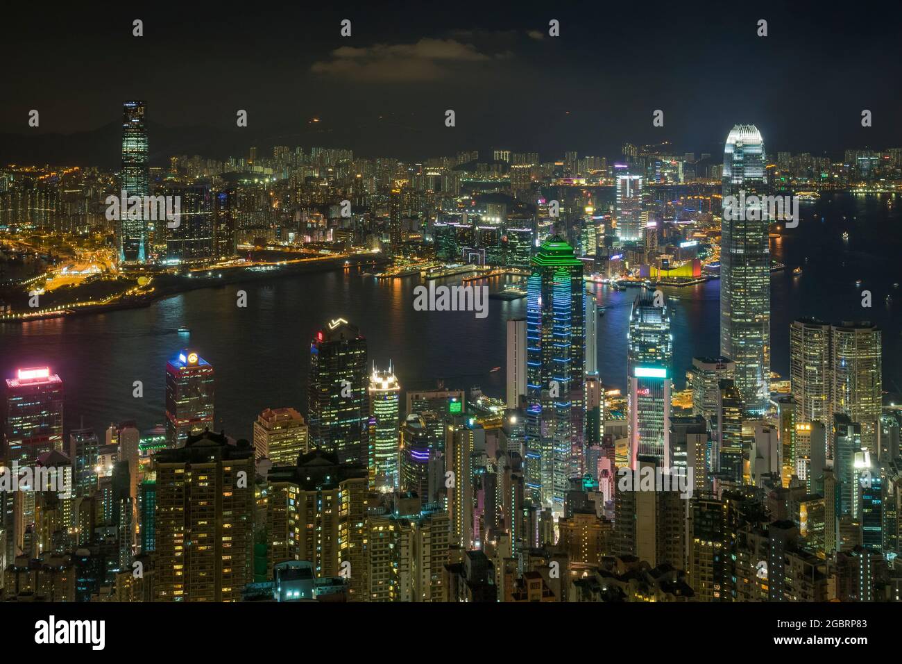 The skyscrapers and high density highrise urban landscape of Mid-levels and Central on Hong Kong Island, and Kowloon across Victoria Harbour, at night Stock Photo