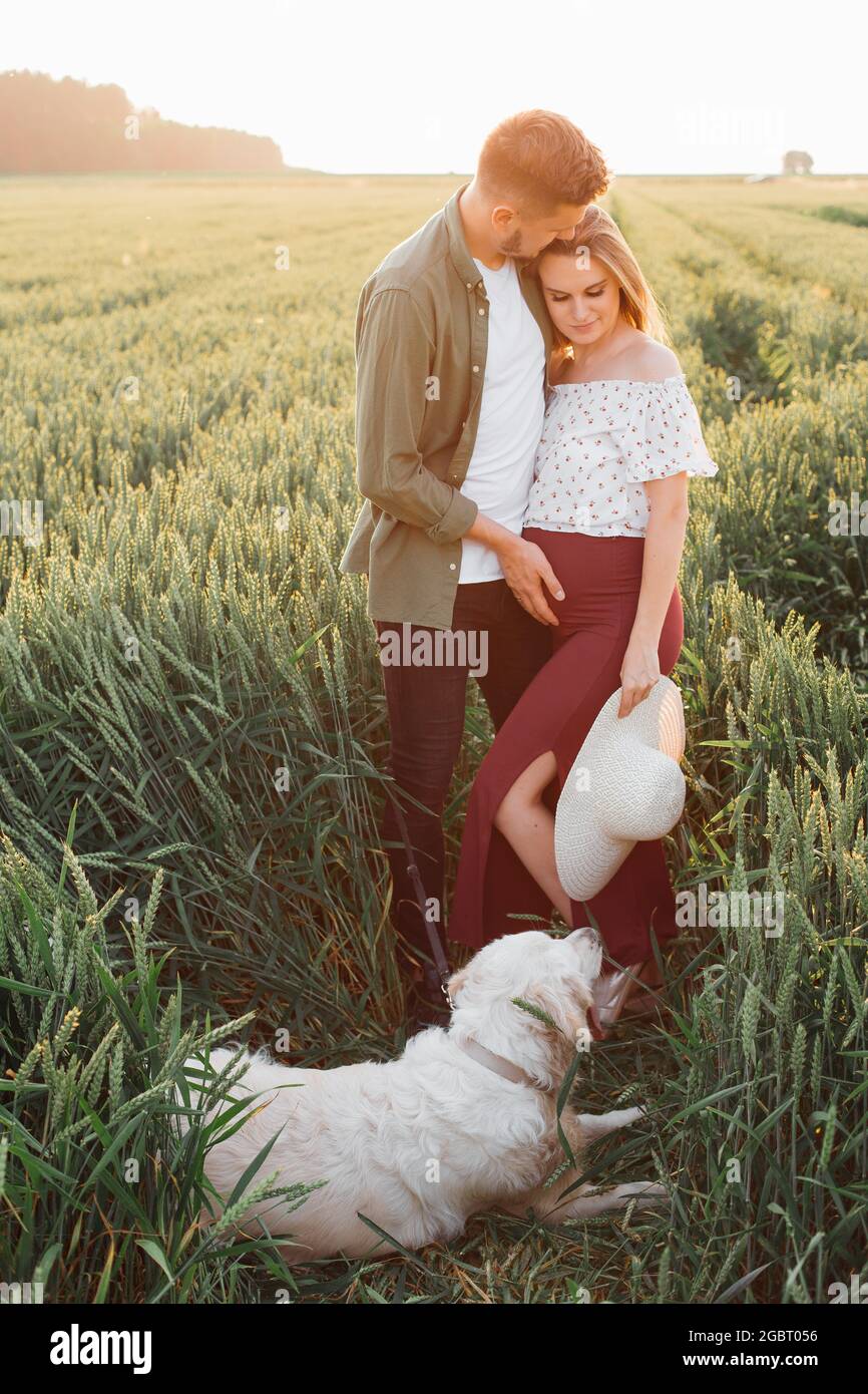 Time in nature for pregnant couple walking with their dog . Pregnant woman . Family and pregnancy. Love and tenderness. Happiness and serenity. Taking Stock Photo