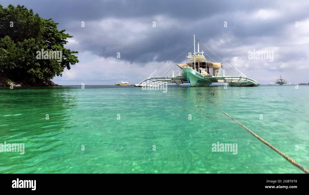 boat tied to a rope in the water Stock Photo - Alamy