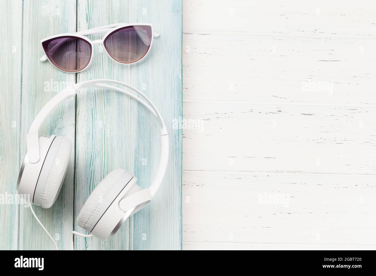 Sunglasses and headphones on wooden backdrop. Travel and vacation concept. Top view flat lay with copy space Stock Photo