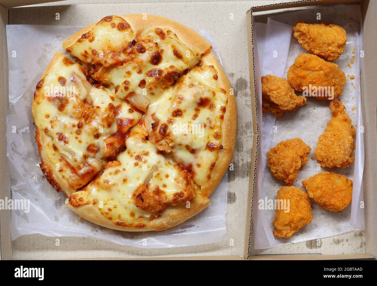 Top view of Pizza in brown paper box and fried chicken, a junk food