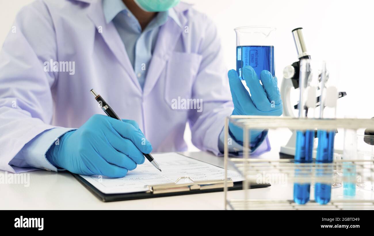 Young Asian scientist Working looking through a microscope doing ...