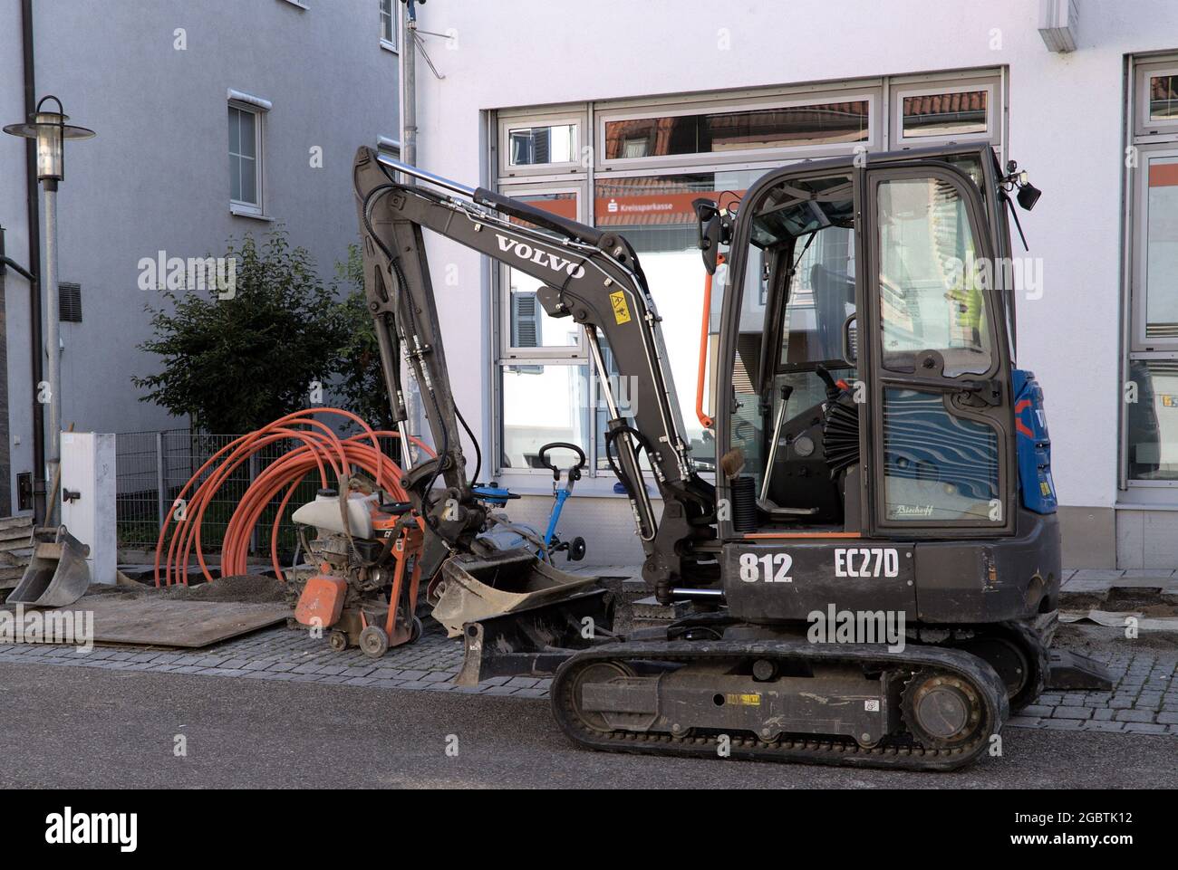 Excavator and fiber optic cable on a construction site during broadband expansion in road construction for broadband supply with the fast Internet Stock Photo