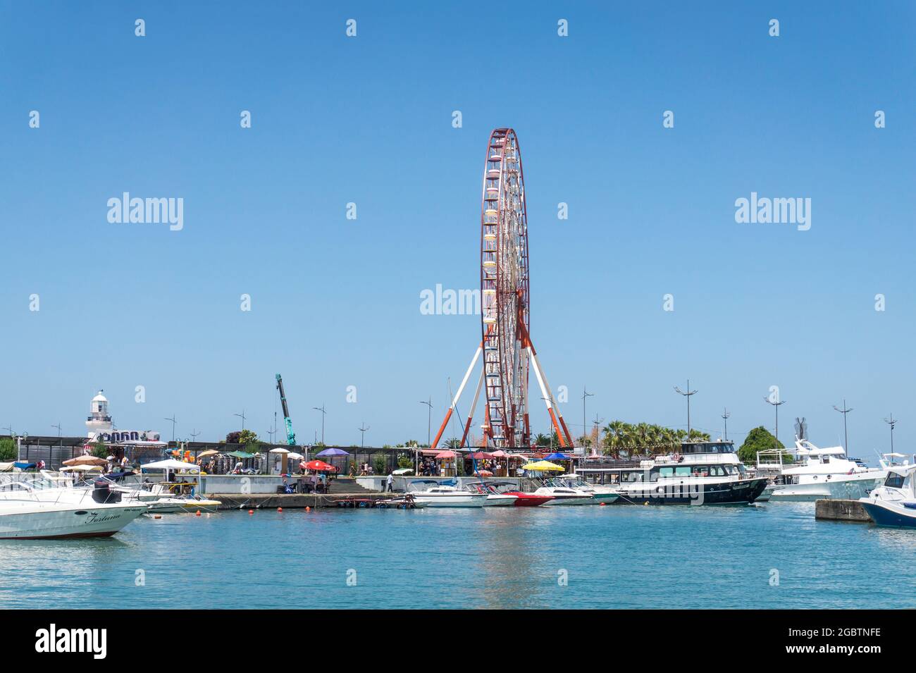 Batumi, Georgia - July 2, 2021: Batumi coastline. Popular Georgian resort city at Black Sea. Panoramic view of Ferris wheel, alphabetic tower, skyscrapers and the beach from the sea. Stock Photo