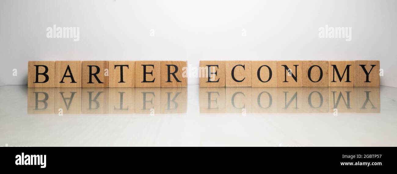 The name Barter Economy was created from wooden letter cubes. Stock Photo