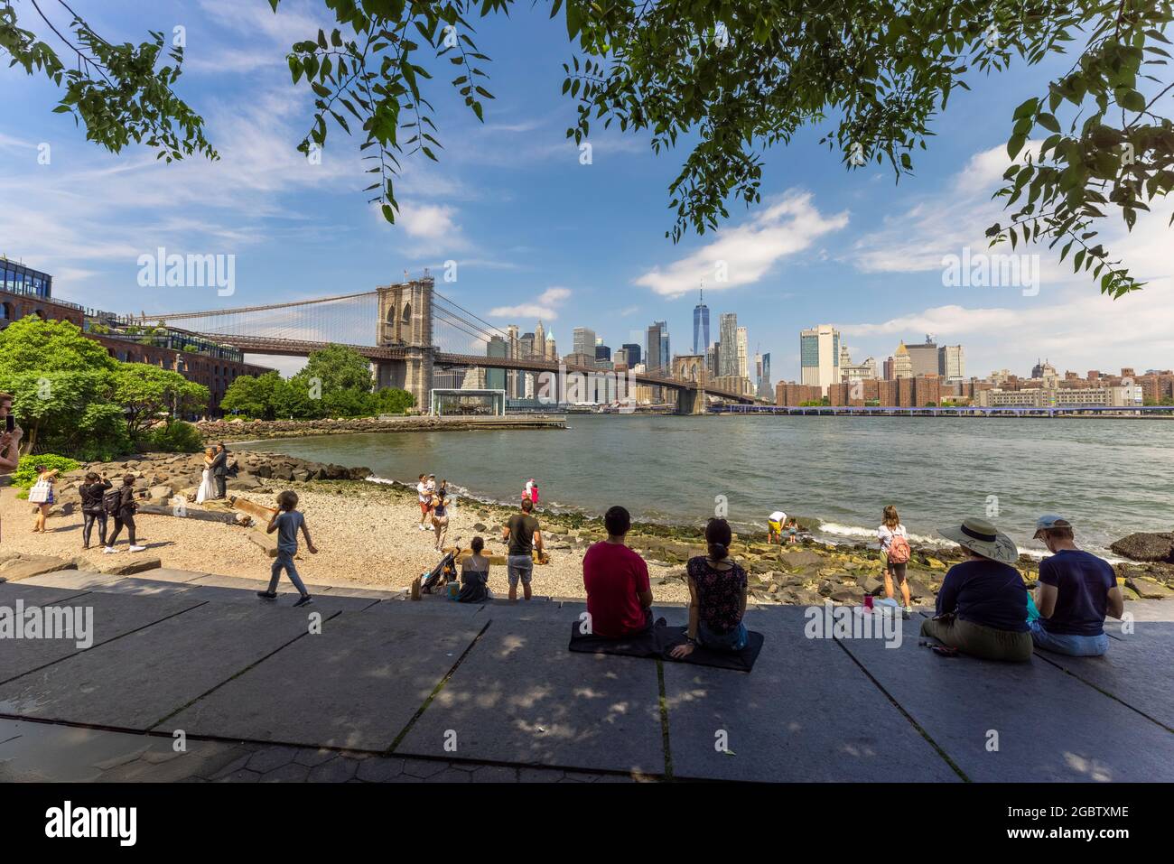 People relax on the Beach of Brooklyn Bridge Park amidst Pandemic NYC. Stock Photo
