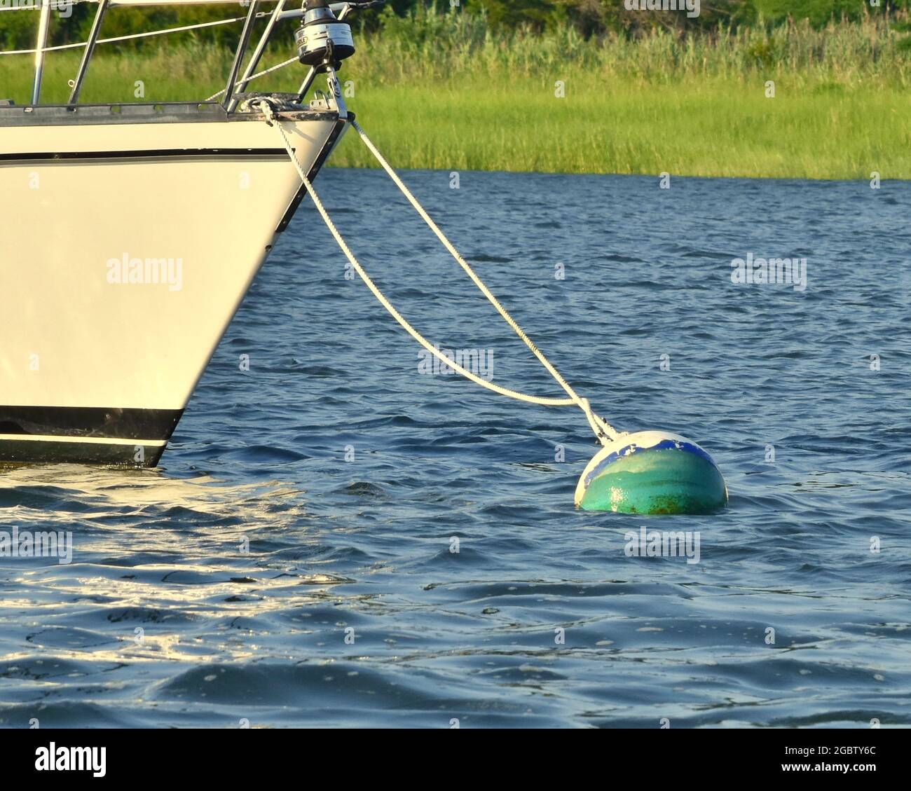 Sailboat at mooring with marsh grass in background. Setauket Harbor, Long Island, New York. Copy space. Stock Photo