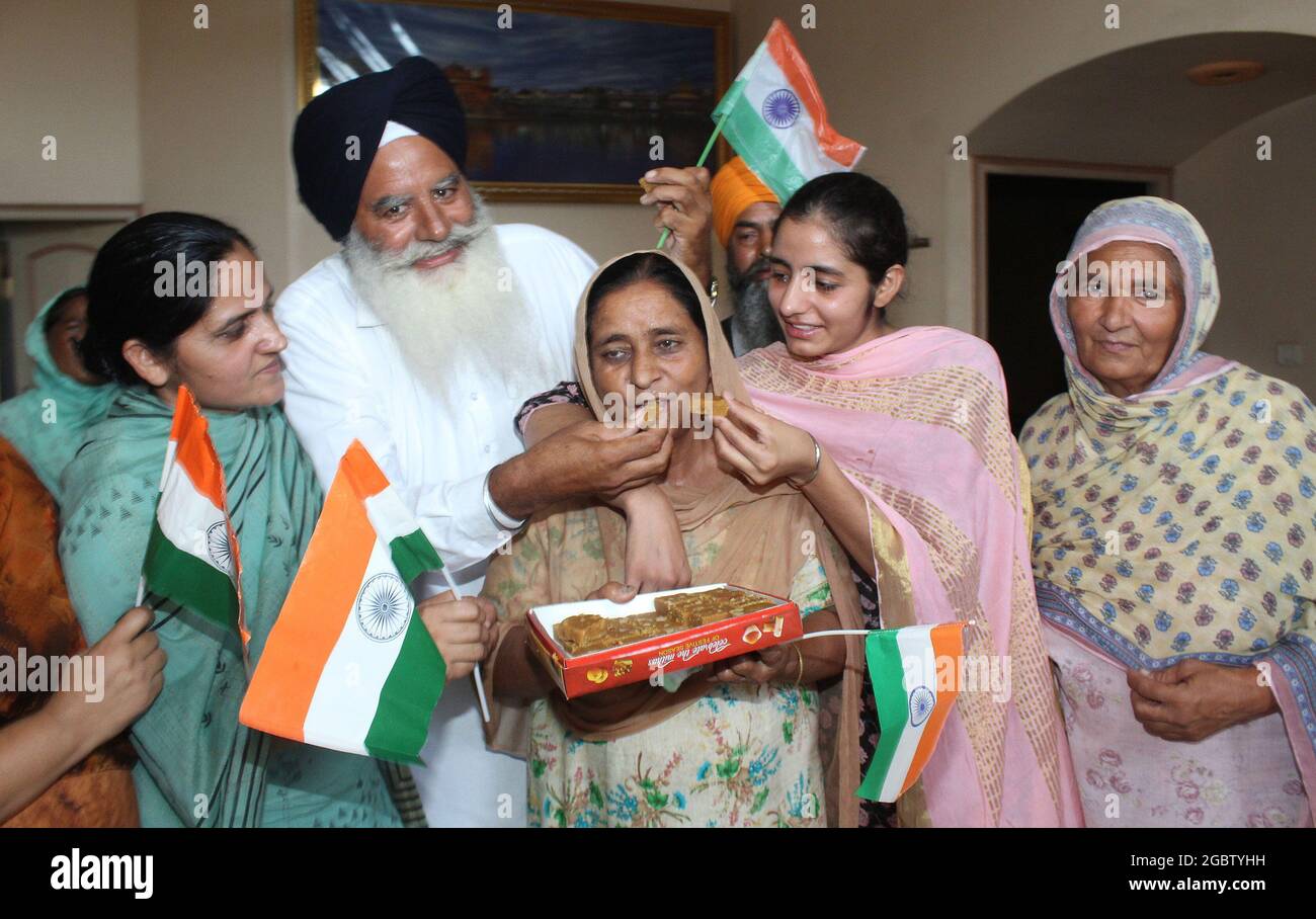 AMRITSAR, INDIA - AUGUST 5: Father Baldev Singh (2L), mother Sukhjinder Singh (C), Sister Gurpreet Kaur (2-R) and relatives of India's field hockey player Gurjant Singh celebrate as India's men's hockey team beats Germany clinching the bronze medal at the Tokyo 2020 Olympic Games at Klehara village Jandiala Guru on August 5,2021 in Amritsar, India. Celebratory scenes were witnessed across India on Thursday after Indian men's hockey team rewrote history by claiming an Olympic medal after 41 years, with families of players saying they made the country proud. A resolute Indian team defeated a plu Stock Photo