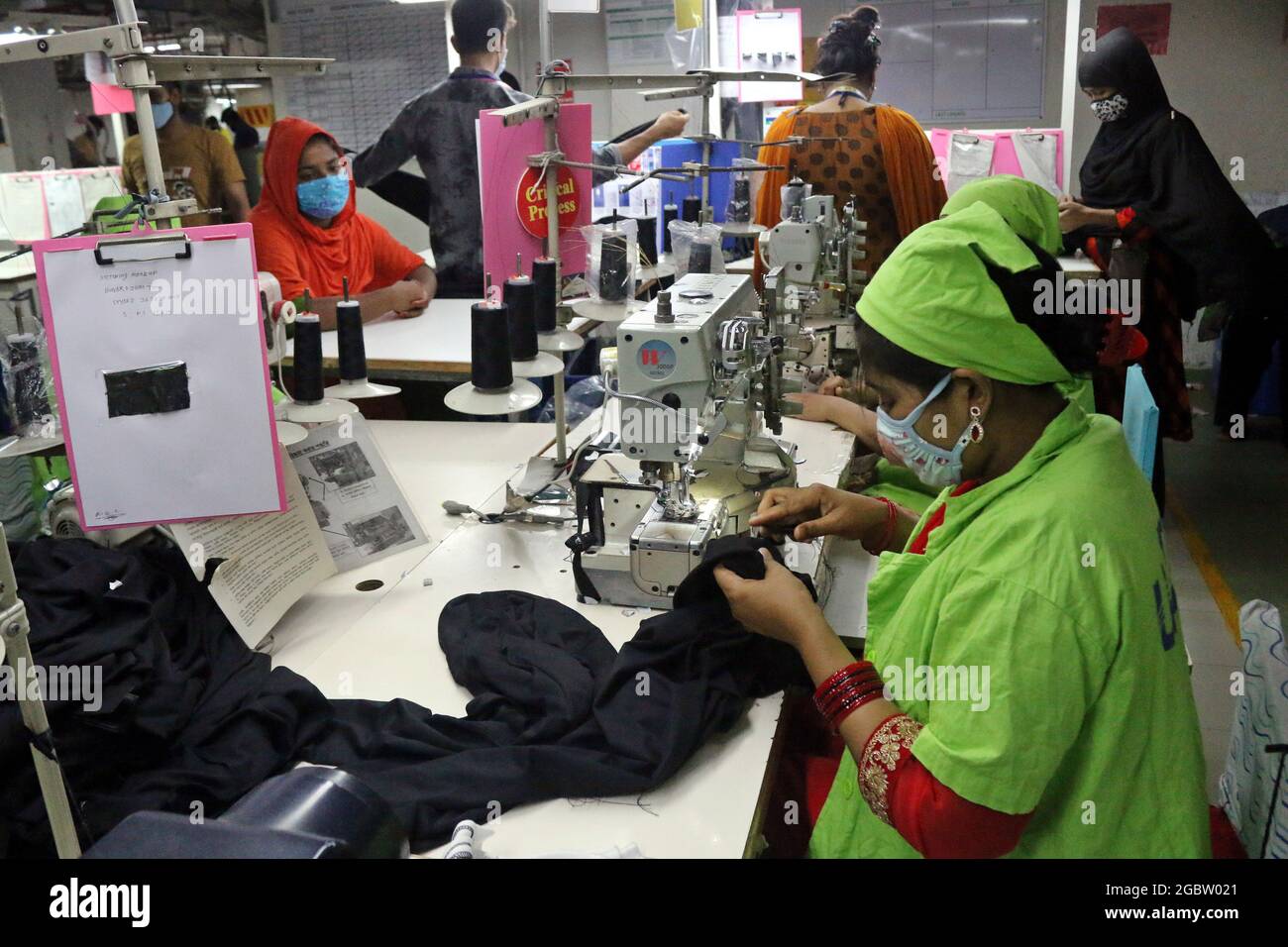 Dhaka, Bangladesh. 04th Aug, 2021. Dhaka, Bangladesh, August 4, 2021: A woman wears face mask as new safety protocol, while manufactures clothes, after authorities have allowed the resumption of activities after a new outbreak of Covid-19. Despite reaching the highest peak of positive cases, Factories resumed the production of clothes to avoid more unemployment . Credit: Habibur Rahman/Eyepix Group/Alamy Live News Credit: Eyepix Group/Alamy Live News Stock Photo